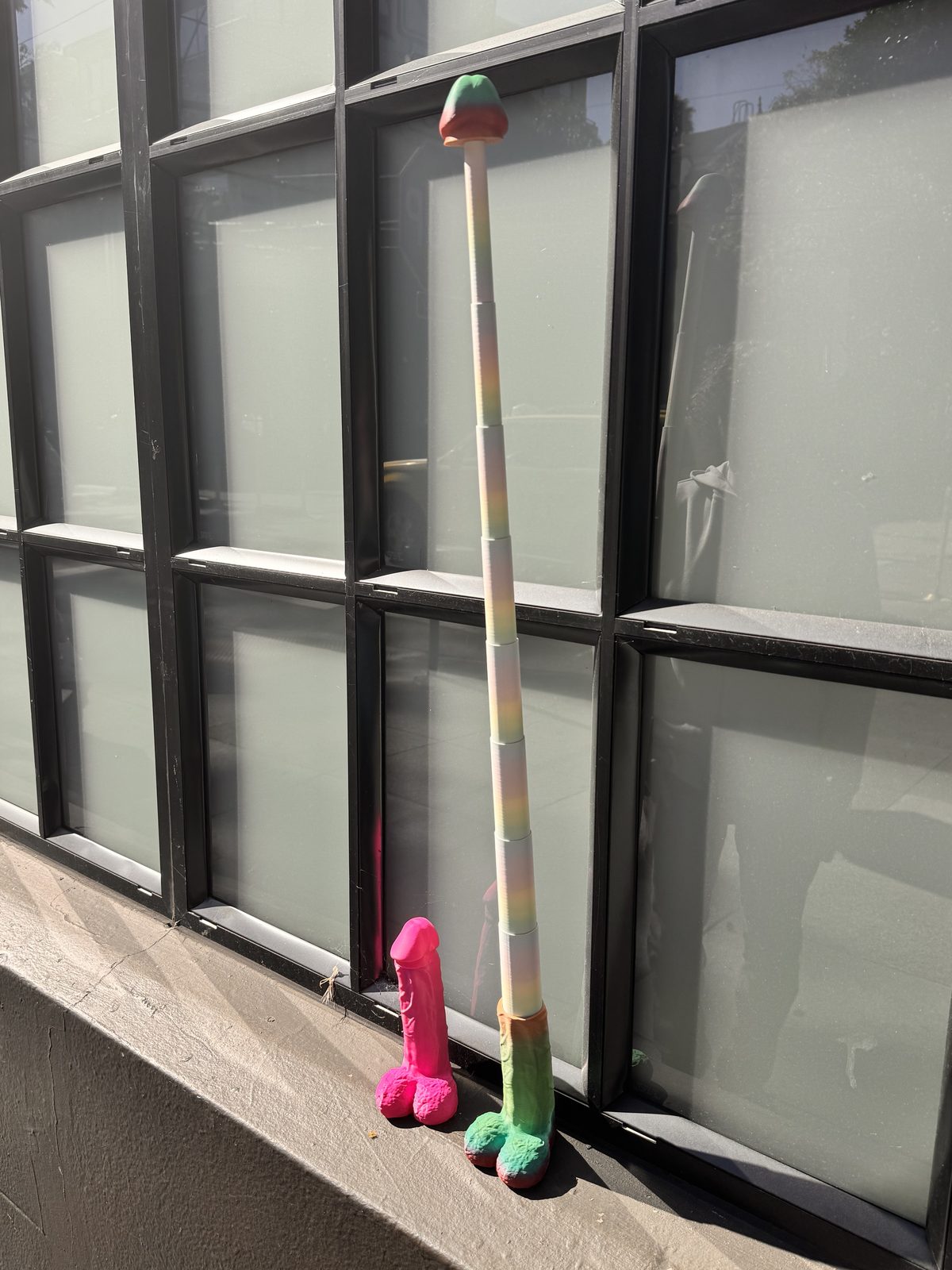 Two tall Dickstendo objects leaning by windows